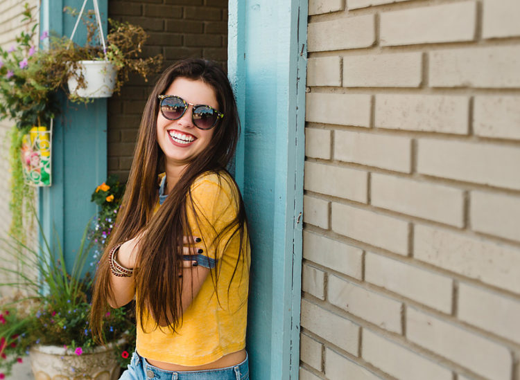 girl leaning on building wall in alley