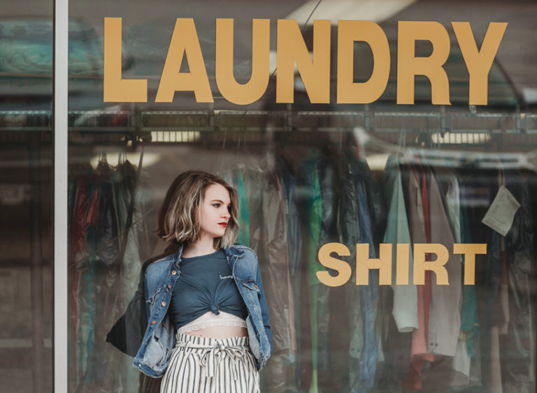 girl standing in front of laundromat