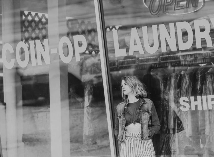 girl in denim jacket outside of laundromat