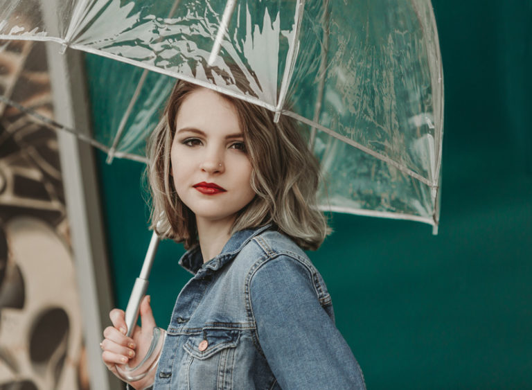girl holding umbrella in front of store
