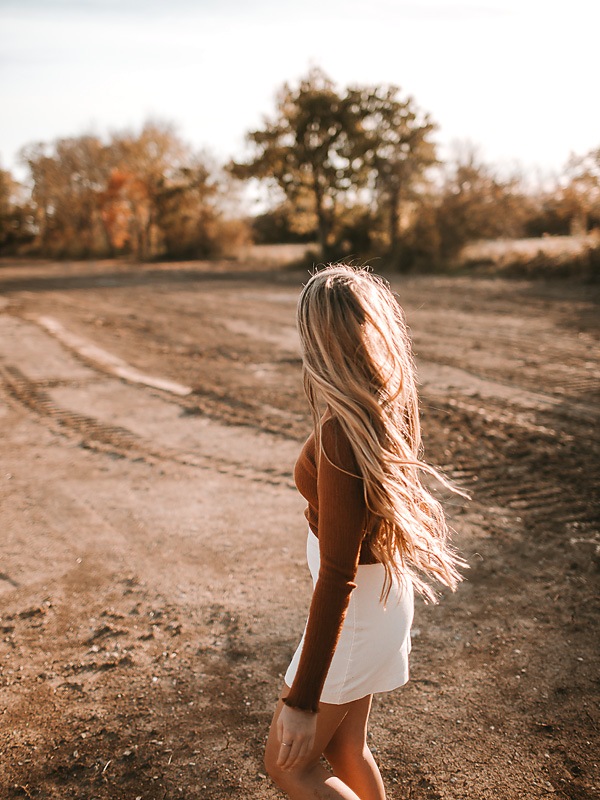 open desert area with girl wearing hat in orange shirt