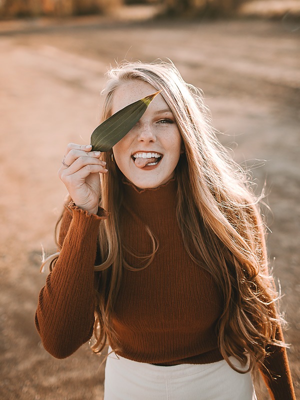 open desert area with girl wearing hat in orange shirt