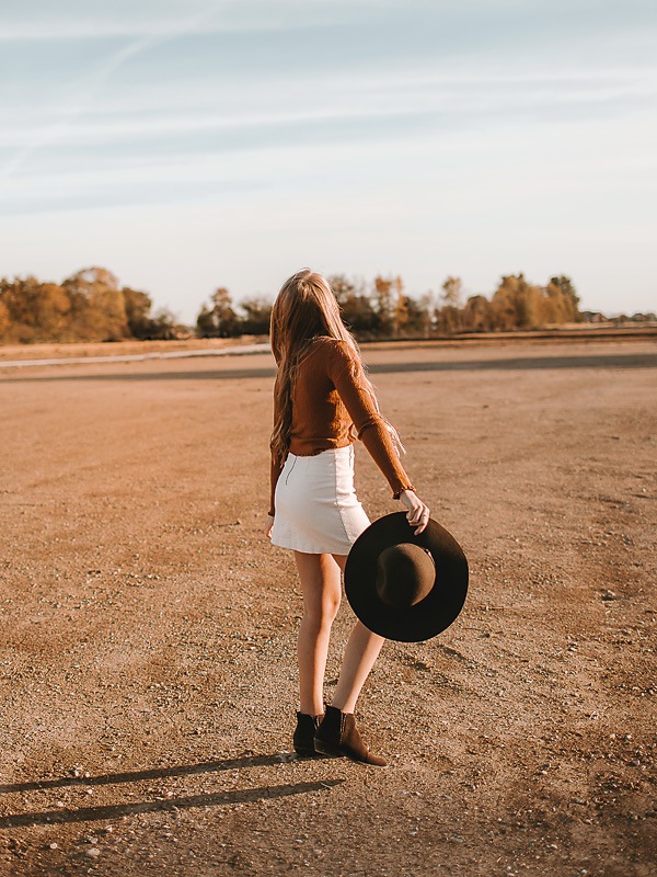 girl dancing in desert holding hat