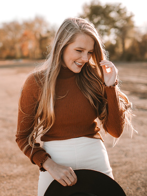 open desert area with girl wearing hat in orange shirt