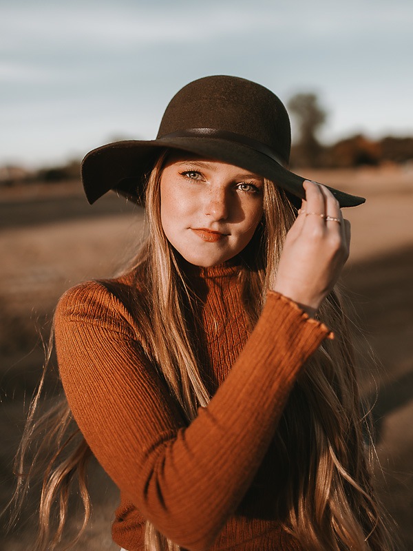 open desert area with girl wearing hat in orange shirt