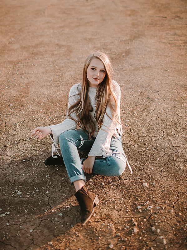 open desert area with girl wearing hat in orange shirt