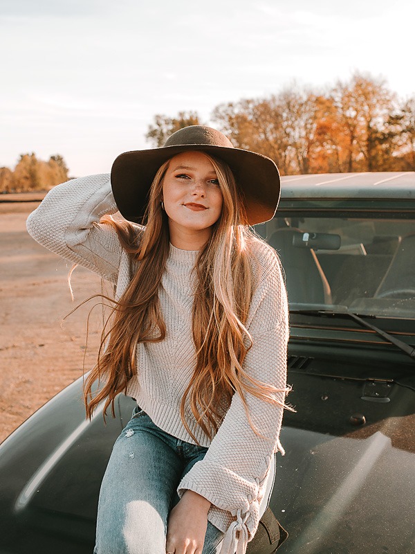 open desert area with girl wearing hat in orange shirt