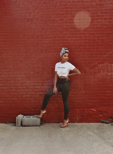 woman standing on one foot in front of red wall