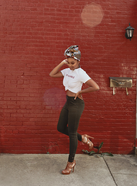 woman standing on one foot in front of red wall