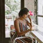 woman drinking coffee in shop reading a book