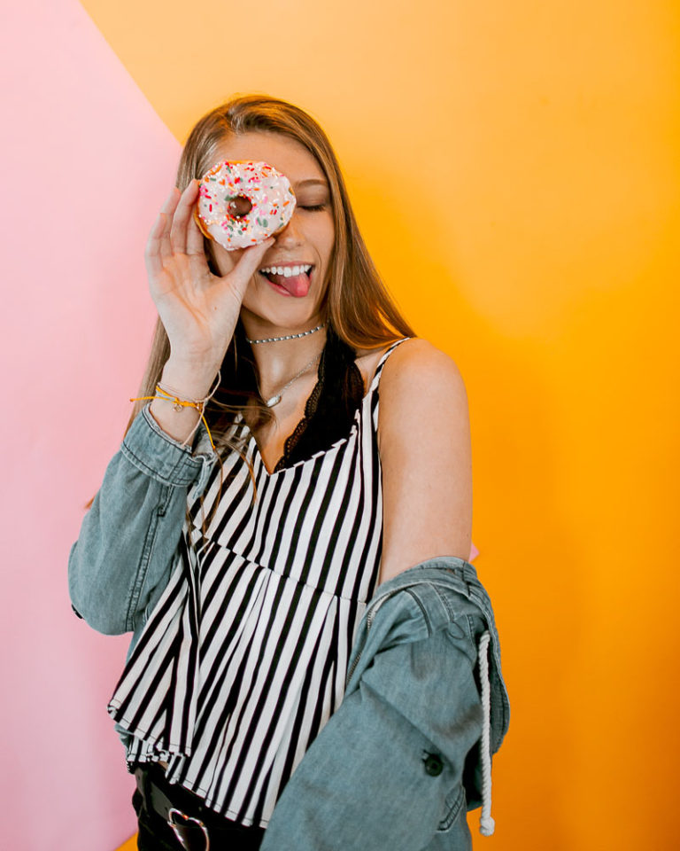 teenager holding donut wearing stripe shirt