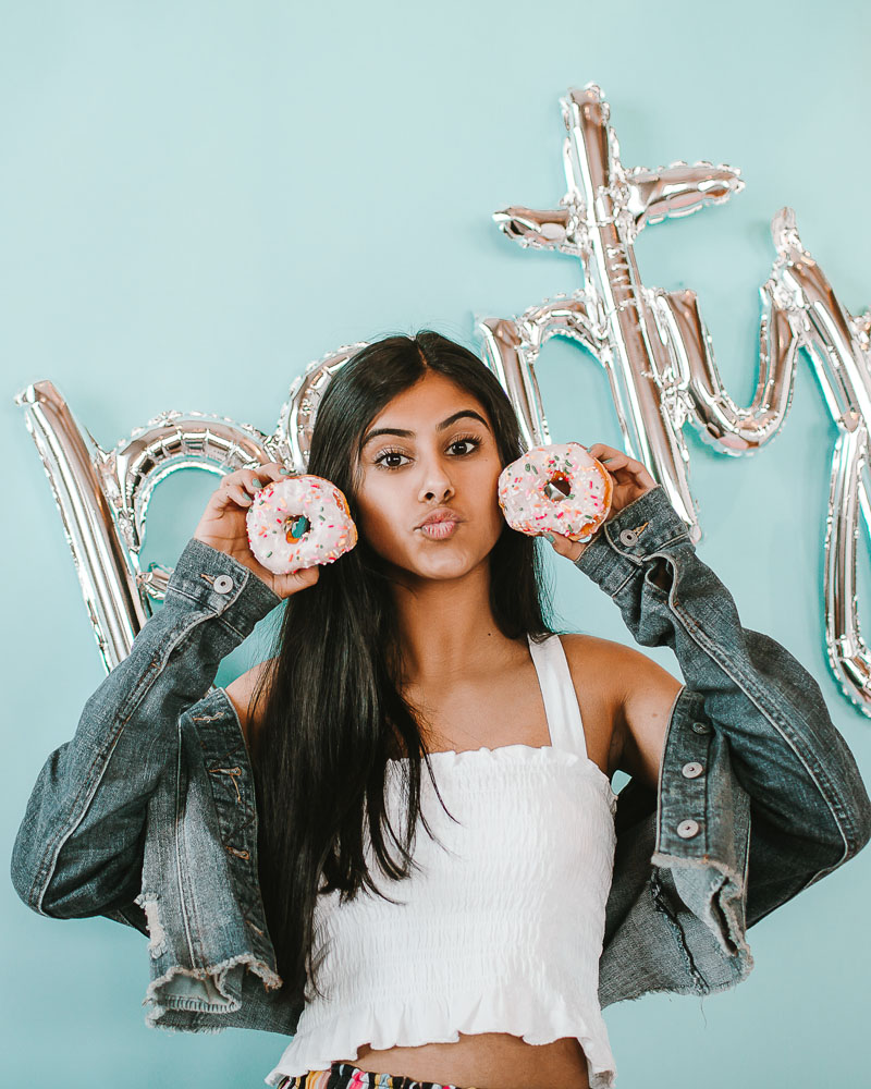 young student holding donuts