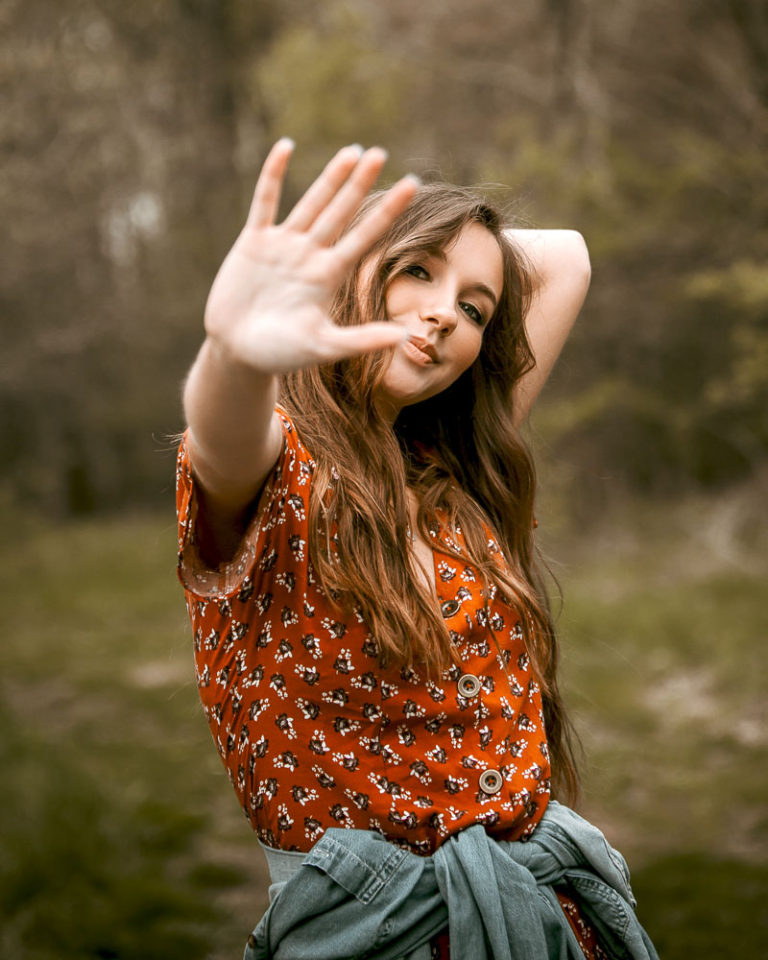 girl waving at camera to stop