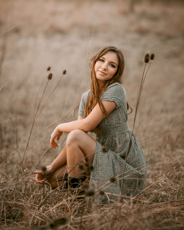 girl in grassy field kneeling