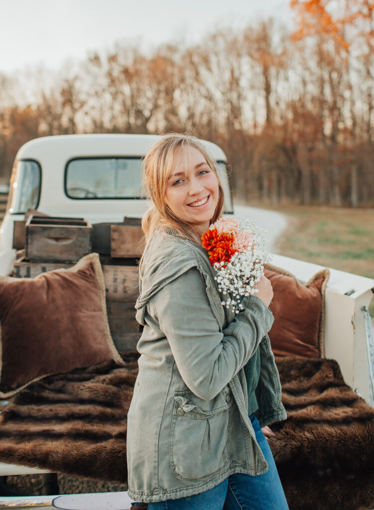 teenager holding flowers in front of truck